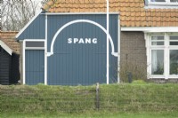 Porte d'écurie peinte en bleu avec le nom de la maison de Nieteke Roeper : Spang.
