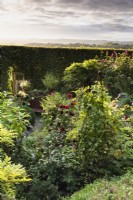 Vue sur un jardin du Dorset depuis le rempart du fort de colline de l'âge de fer qui forme sa limite en septembre.