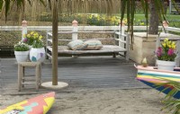 Inspiration Jardin de plage avec banc en bois à Keukenhof. Pots remplis de fleurs printanières.