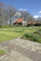 Des rangées de narcisses blancs plantés dans la pelouse devant la maison de Boschhoeve.