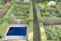 Vue sur une grande surface de haies formelles d'ifs taillés contenant des 'chambres' de jardin, y compris un bassin réfléchissant. Juillet. Image prise depuis un drone.