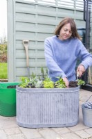 Femme remplissant un grand pot de compost