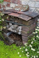 Petit hôtel bug fabriqué à partir de briques et de tuiles avec des bûches, des cannes de bambou et des cônes de sapin offrant un refuge pour les insectes - Hidden Gardens Day, Grundisburgh, Suffolk