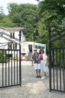 Propriétaires de la Villa Sprezzatura accueillants près du portail en fer noir.
