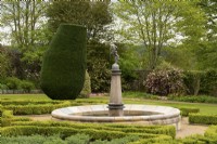 Topiaire Taxus baccata et haie de Buxus autour d'une fontaine dans le jardin de la fontaine du jardin clos du château de Crathes.