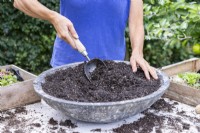 Femme mélangeant le compost et le gravier