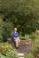 Femme assise dans son jardin en septembre