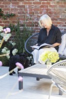 Propriétaire de jardin assis avec un chien en lisant