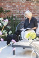 Propriétaire de jardin assis avec un chien en lisant