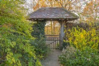 Vue à travers une entrée couverte du jardin de la porte lych en automne - novembre