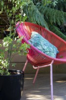 Une chaise de style contemporain ajoute de la couleur au jardin.