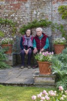 Propriétaires de jardin assis sur un banc dans le jardin clos.