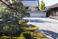 Bordure du jardin zen principal de gravier ratissé, connu sous le nom de karesansui, qui se traduit par « eau sèche de montagne ». Placer des roches et des arbres dans un parterre de mousse. Vue sur les bâtiments du temple.