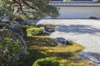 Bordure du jardin zen principal de gravier ratissé, connu sous le nom de karesansui, qui se traduit par « eau sèche de montagne ». Placer des roches et des arbres dans un parterre de mousse.