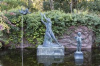 Trois statues dans un bassin au bord du jardin en contrebas. 