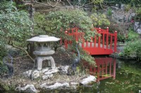Lampe orientale et pont rouge dans le jardin japonais de Compton Acres, Canford Cliffs, Dorset en mars 