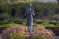La statue de la Lampe de la Sagesse entourée de Sedum « Autumn Joy » et de topiaires en boîte dans le jardin à la française des Waterperry Gardens 