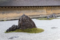Le Rock Garden avec du gravier ratissé et des pierres placées dans des îles de mousse. Murs d'argile avec toits de tuiles. 