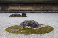 Le Rock Garden avec du gravier ratissé et des pierres placées dans des îles de mousse. Murs d'argile avec toits de tuiles. 