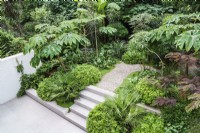 Marches et allée de gravier à travers un jardin tropical moderne 