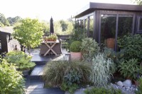 Jardin contemporain avec terrasse en bois et bureau de jardin 