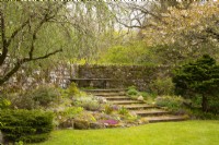 Fleurs de printemps dans un jardin de rocaille autour de marches en pierre bordées par un mur de pierre dans les jardins du château de Cawdor 
