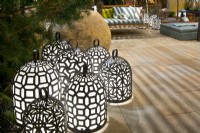 Groupe de lampes luminescentes en laiton faites à la main sur une terrasse en pierre naturelle avec des sièges. Concepteur : Vetschpartner, Berger Gartenbau et Livingdreams. Giardina-Zurich, Suisse. 