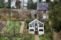 Serre blanche dans le jardin clos de Cerney House en mars 