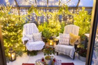 Grande serre meublée et décorée de chaises en plastique recyclé, de guirlandes lumineuses et de plantations mixtes 